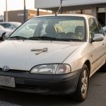 Voiture d’occasion garée dans un parc automobile, avec une seule clé métallique posée bien en évidence sur le capot.