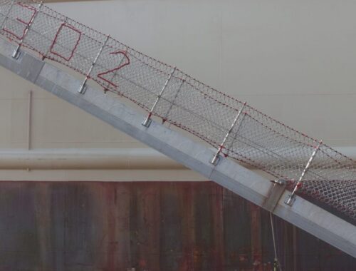 Filet de sécurité installé le long d’un escalier intérieur dans une maison.